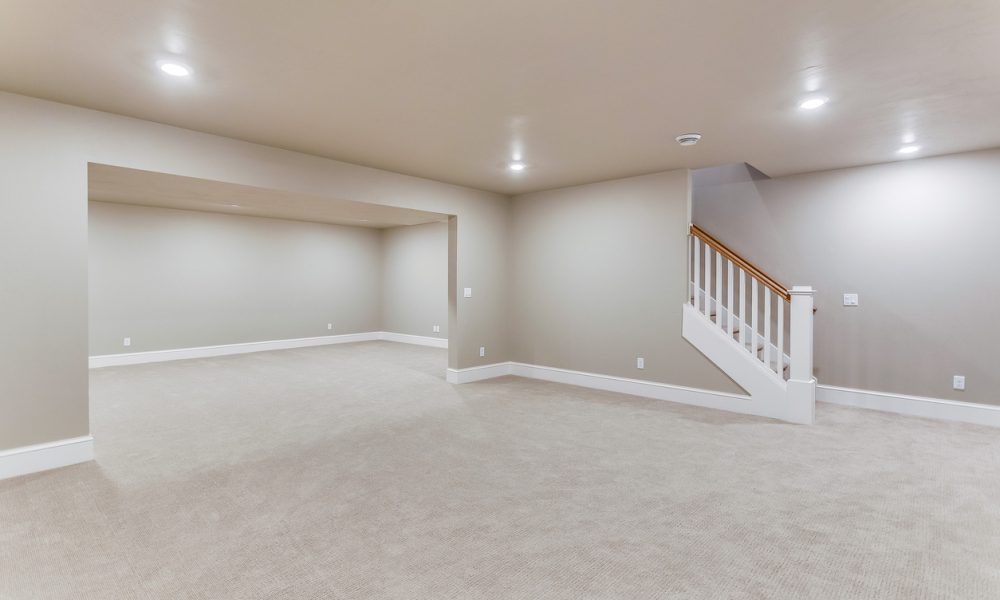 Light colored carpet with plenty of LED wafer lights to make this basement bright
